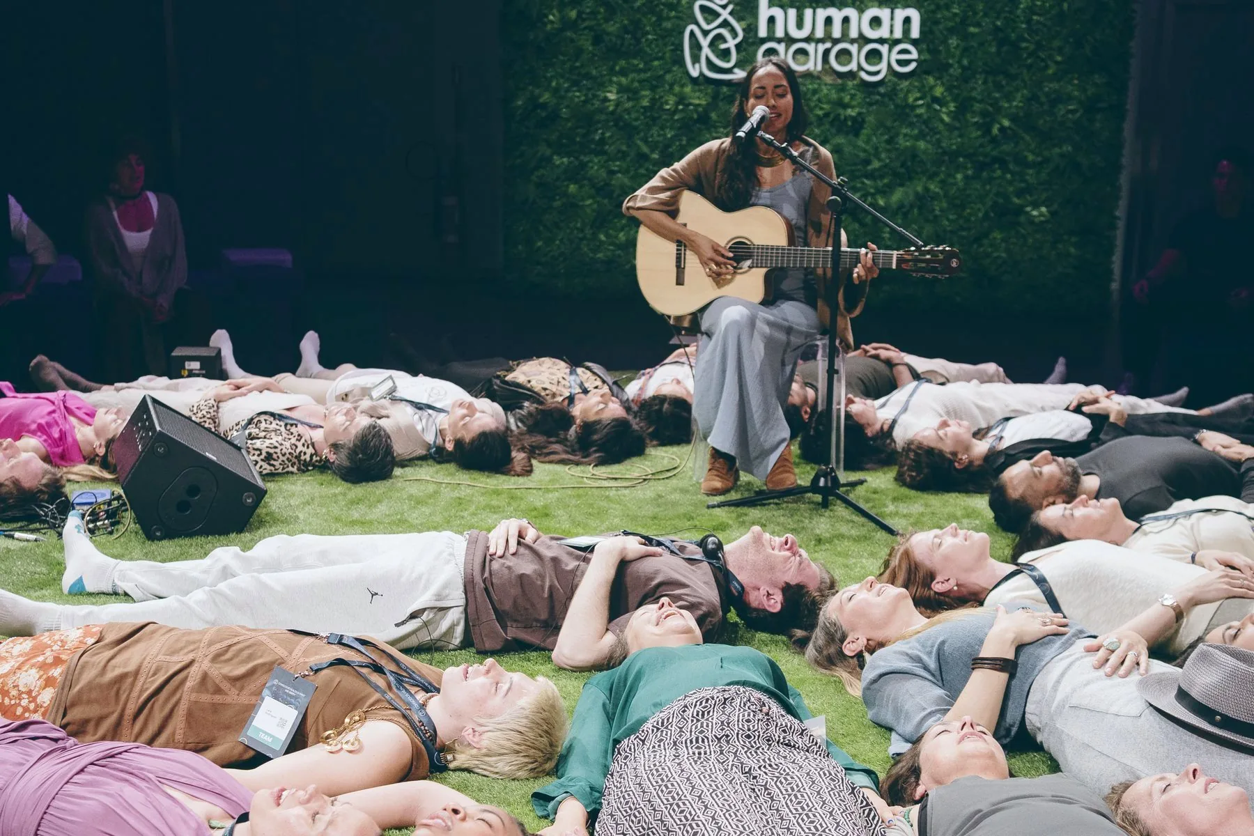 A workshop on the grass with a guitarist in the Wisdom Circle, 2025